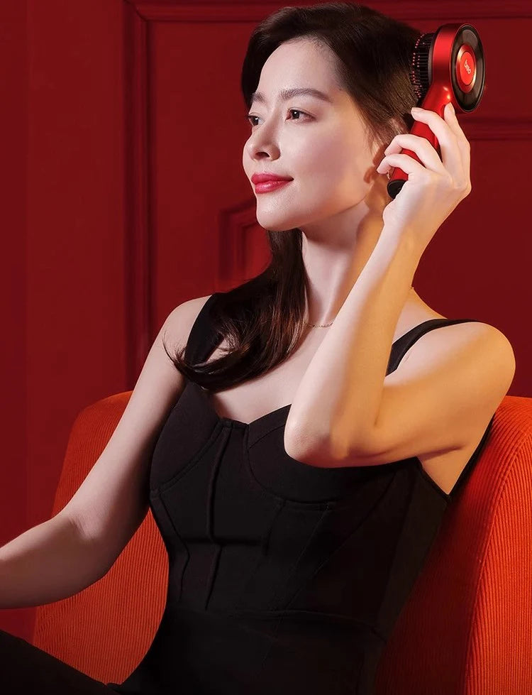 Elegant woman using the red Scalp Trio massager for luxurious hair care and relaxation.